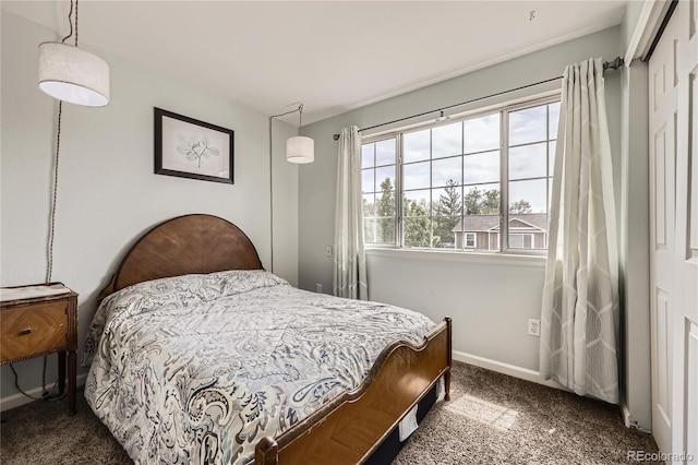 carpeted bedroom with baseboards and a closet