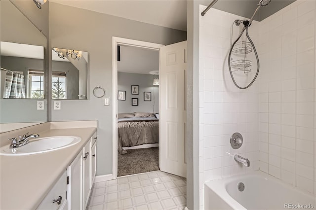 ensuite bathroom with vanity, shower / bathtub combination, tile patterned floors, and baseboards