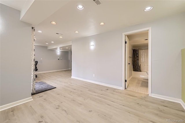 spare room featuring recessed lighting, light wood-style floors, and baseboards