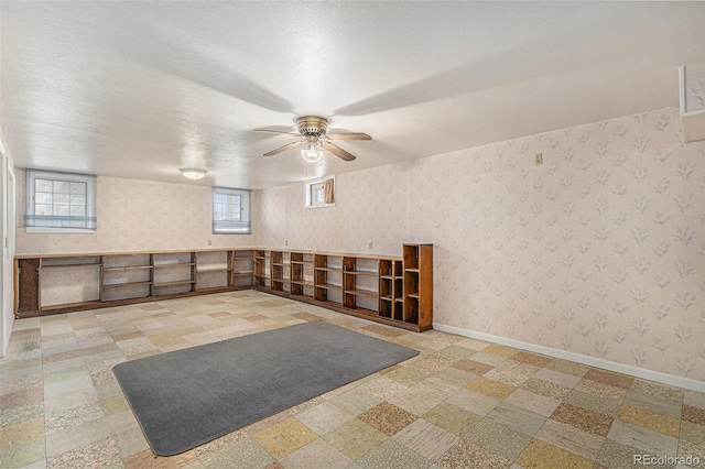 spare room featuring tile patterned floors, baseboards, a ceiling fan, and wallpapered walls