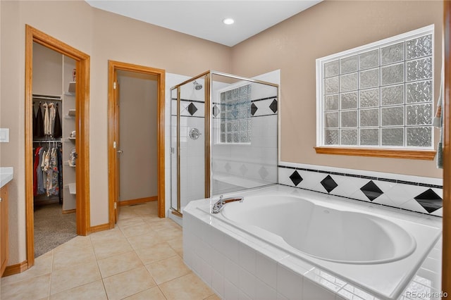 34827 E 7th Ave, Watkins, CO 80137 - full bathroom featuring a bath, a shower stall, a spacious closet, and tile patterned floors