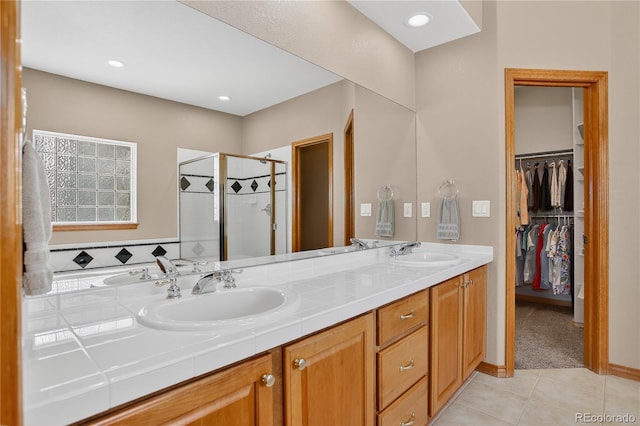 34827 E 7th Ave, Watkins, CO 80137 - full bathroom featuring a stall shower, tile patterned floors, double vanity, and a spacious closet