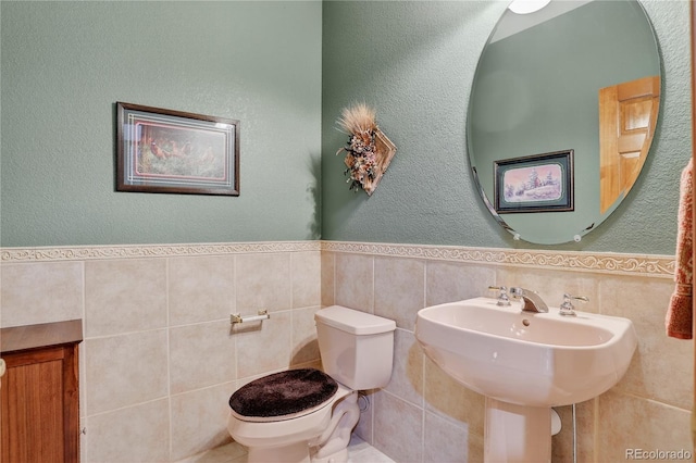 34827 E 7th Ave, Watkins, CO 80137 - bathroom with tile walls, a wainscoted wall, and a textured wall