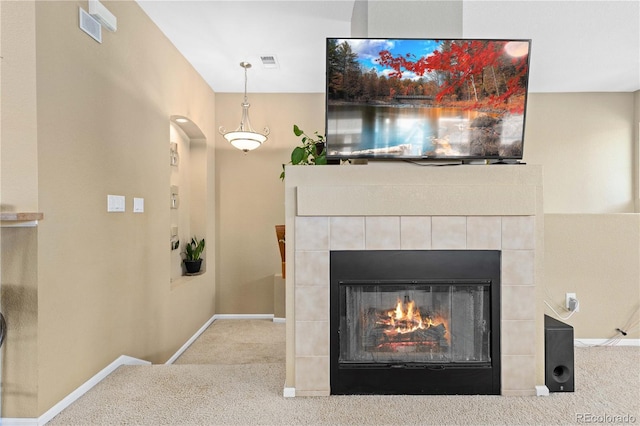 details featuring carpet floors, a tile fireplace, visible vents, and baseboards