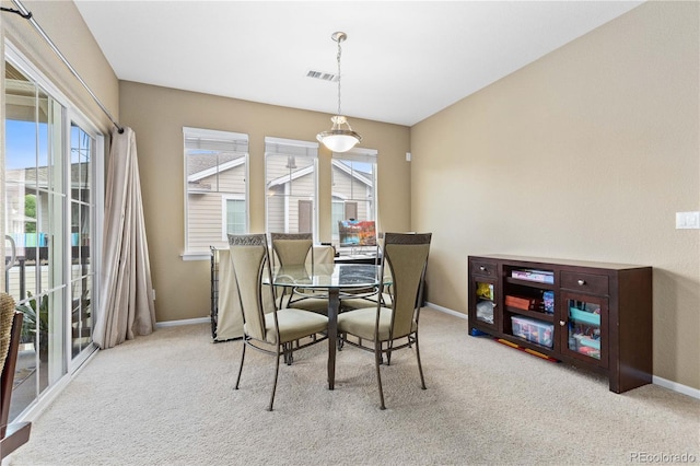 carpeted dining space with visible vents, plenty of natural light, and baseboards