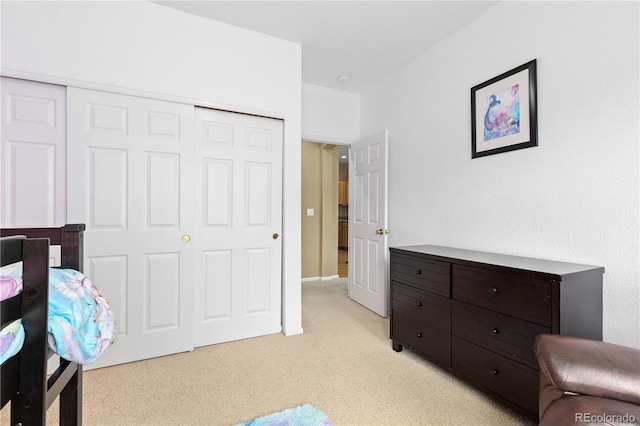 bedroom featuring light carpet and a closet