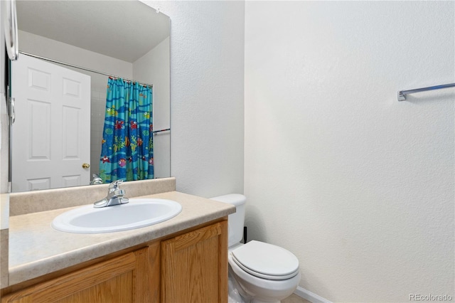 bathroom with a textured wall, a shower with shower curtain, vanity, and toilet