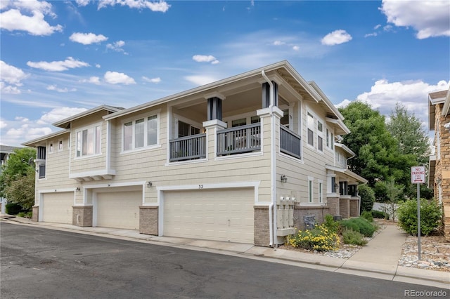 view of front of home with brick siding, a balcony, and an attached garage