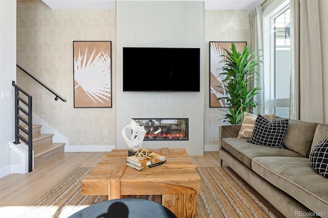 living room with a large fireplace and hardwood / wood-style flooring