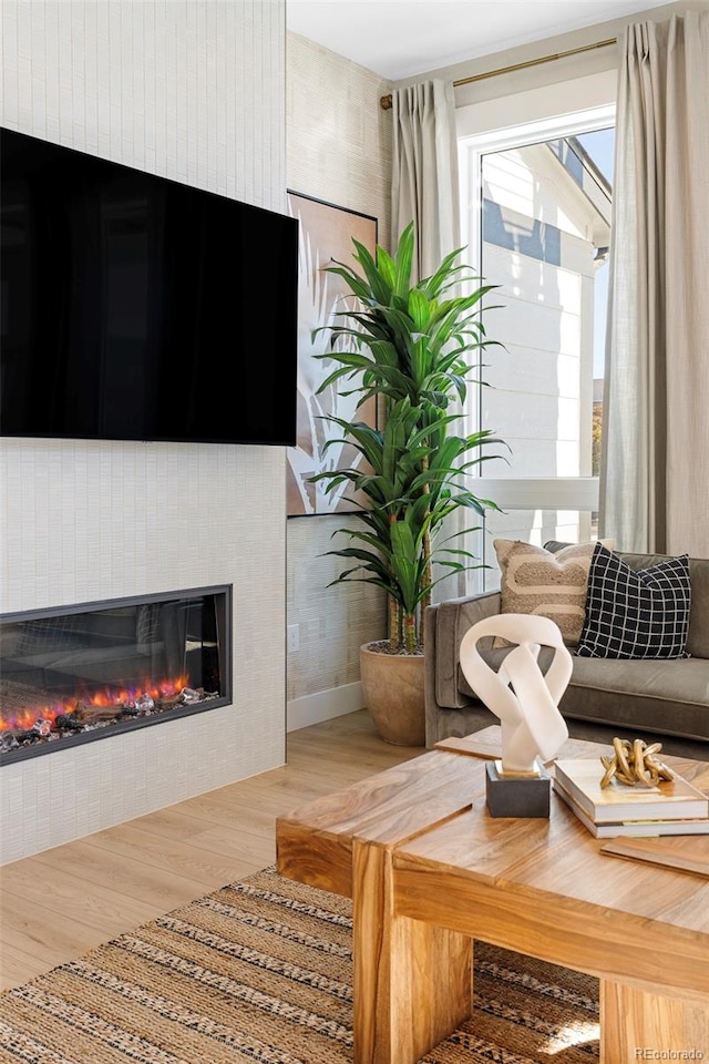 living area featuring a tile fireplace and hardwood / wood-style flooring