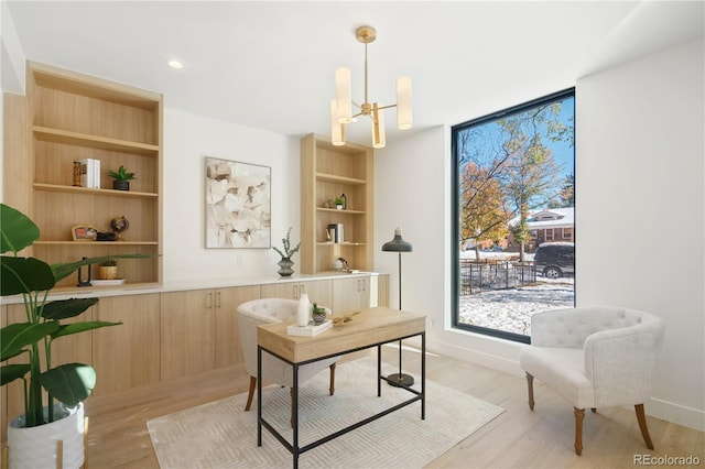 home office with a notable chandelier and light wood-type flooring