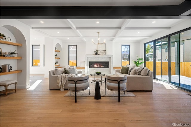 living room with a fireplace, light hardwood / wood-style flooring, beamed ceiling, and coffered ceiling