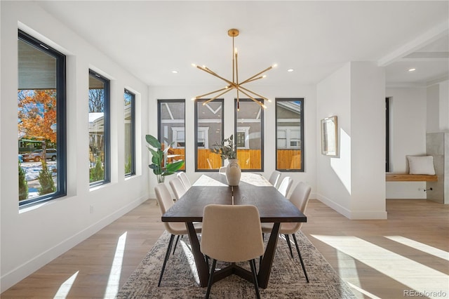 dining area with a notable chandelier and light hardwood / wood-style floors