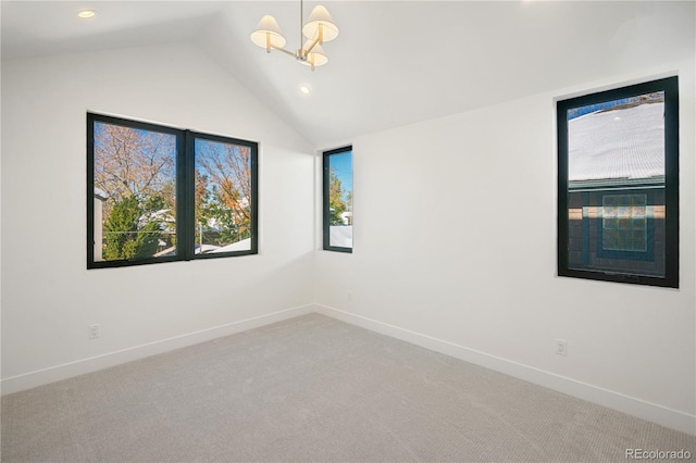 carpeted spare room featuring a wealth of natural light, a chandelier, and lofted ceiling