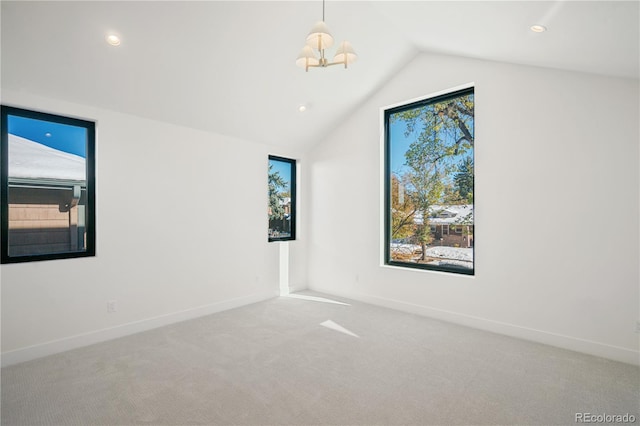 spare room featuring light colored carpet, an inviting chandelier, and lofted ceiling