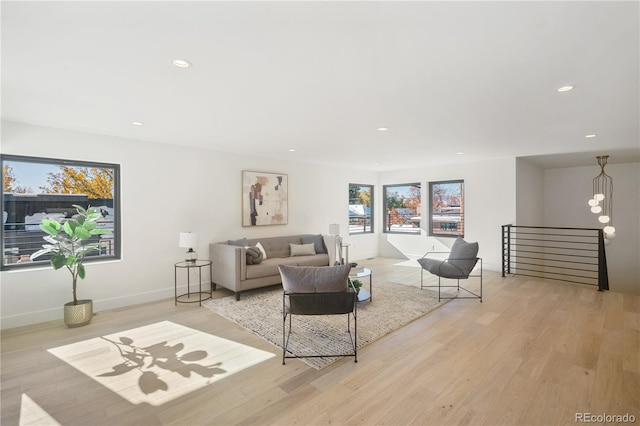 living room featuring light wood-type flooring and an inviting chandelier