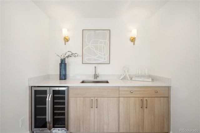 bar featuring light brown cabinets, sink, and beverage cooler