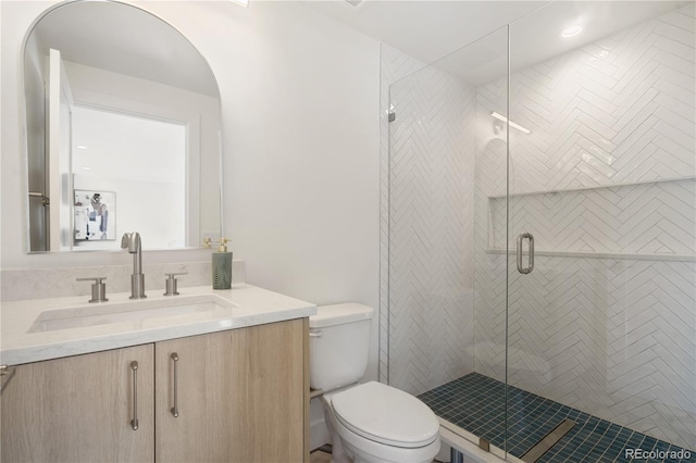 bathroom featuring vanity, toilet, and a shower with door