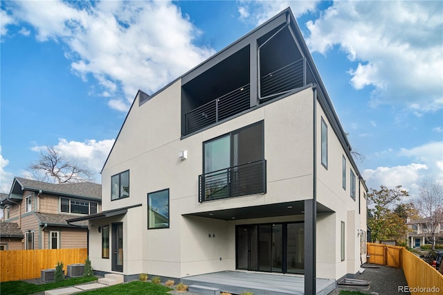 rear view of property featuring central AC unit and a yard