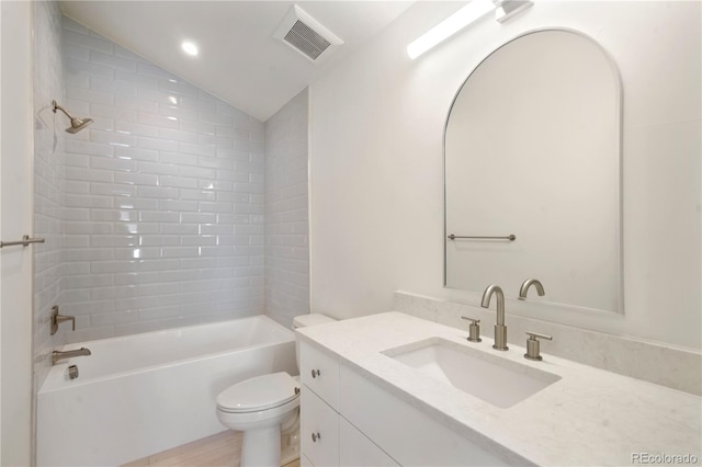 full bathroom with vanity, tiled shower / bath combo, lofted ceiling, and toilet