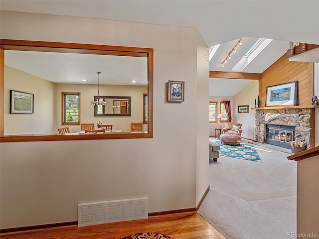 31412 N Bermuda Dunes Dr, Evergreen, CO 80439 - corridor with wood finished floors, lofted ceiling, baseboards, a chandelier, and a skylight