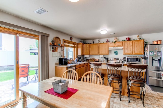 5400 Perth St, Denver, CO 80249 - kitchen featuring stainless steel appliances, light countertops, a sink, and under cabinet range hood