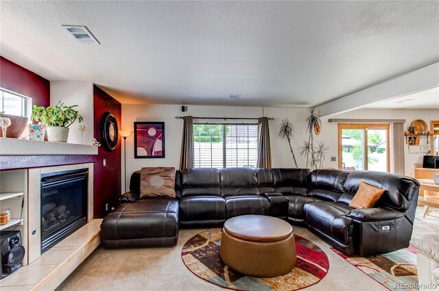 5400 Perth St, Denver, CO 80249 - carpeted living area with a tiled fireplace and a textured ceiling