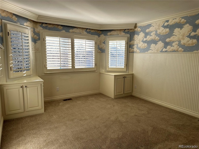 empty room featuring ornamental molding and light colored carpet