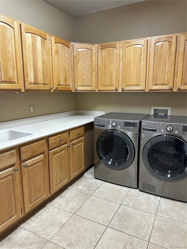 laundry area with cabinets, light tile patterned flooring, and washer and dryer