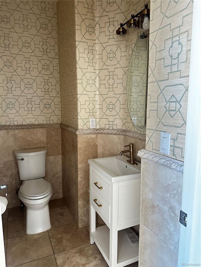 bathroom with vanity, tile walls, tile patterned floors, and toilet