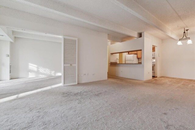unfurnished living room featuring a sink, carpet floors, and a textured ceiling