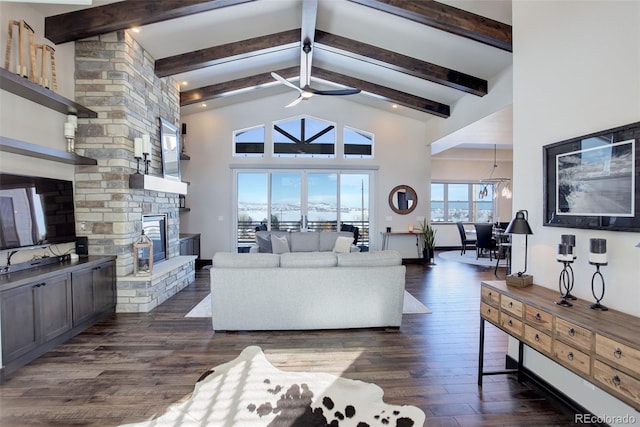 living area featuring a ceiling fan, dark wood-type flooring, a stone fireplace, high vaulted ceiling, and beam ceiling