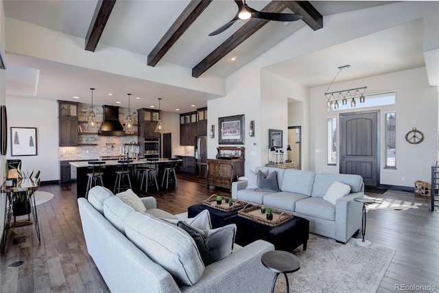 living area featuring high vaulted ceiling, a ceiling fan, baseboards, beamed ceiling, and dark wood finished floors