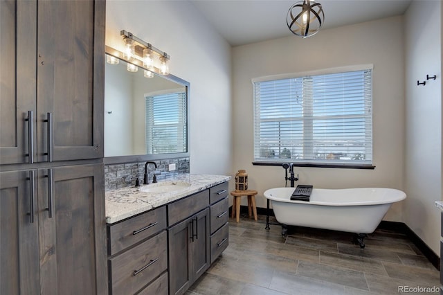 bathroom featuring a freestanding bath, vanity, and baseboards