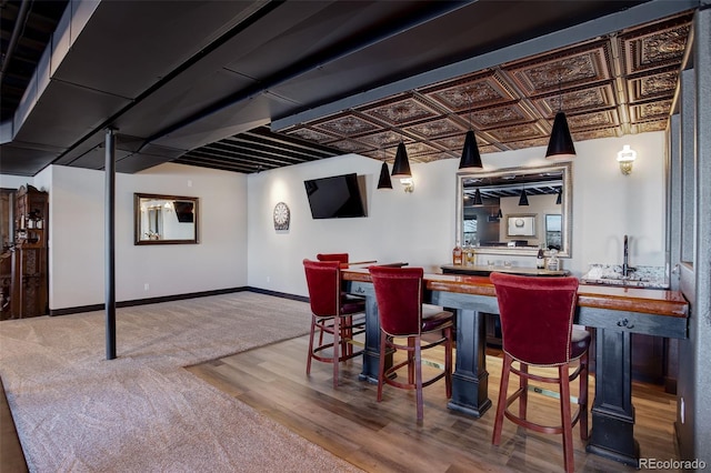 bar featuring wet bar, an ornate ceiling, and baseboards