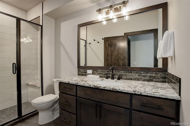 full bathroom featuring tasteful backsplash, toilet, a shower stall, vanity, and tile patterned flooring