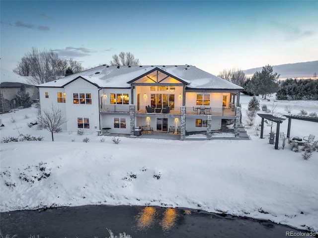 snow covered property featuring a garage and a balcony