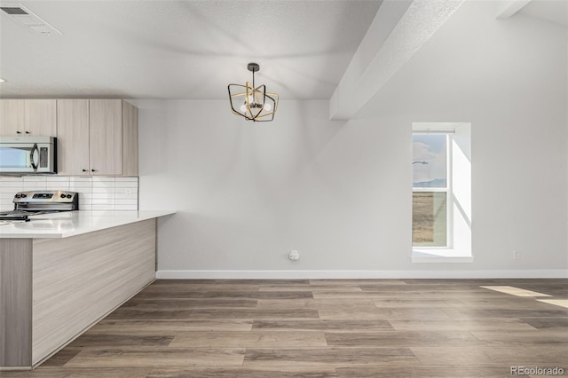 kitchen featuring stainless steel appliances, wood finished floors, visible vents, baseboards, and tasteful backsplash