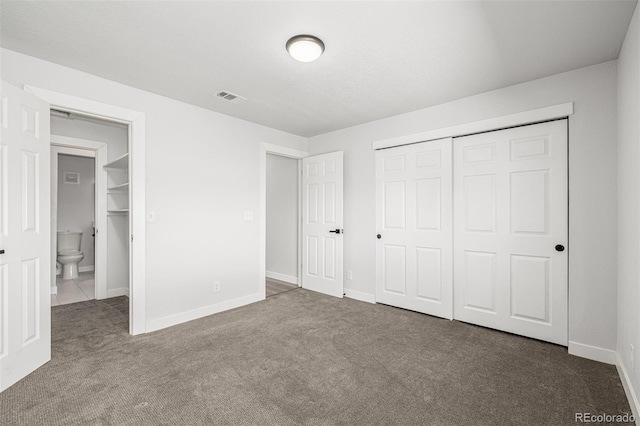 unfurnished bedroom with a closet, carpet flooring, visible vents, and baseboards