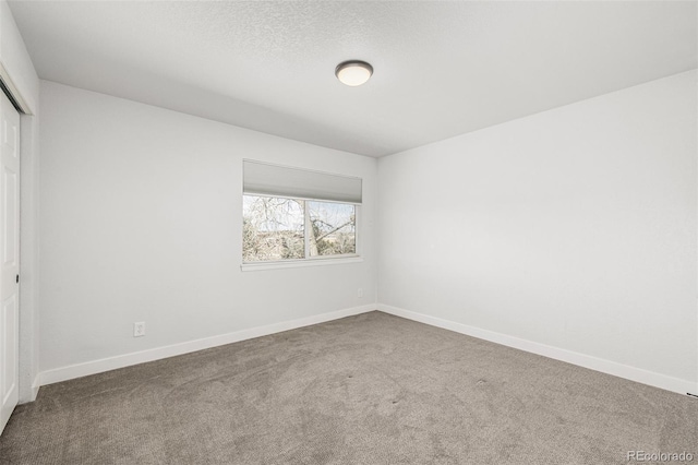 unfurnished bedroom with carpet, a closet, and baseboards