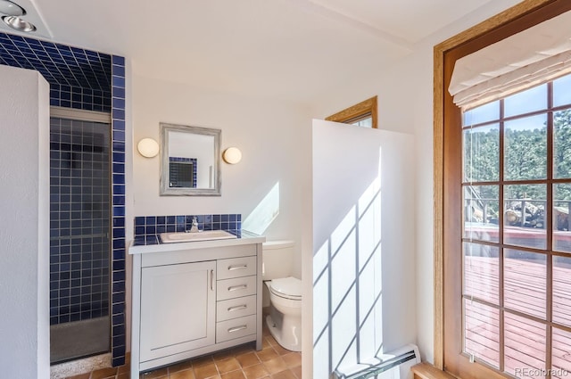 135 Poorman Rd, Boulder, CO 80302 - full bathroom featuring tiled shower, vanity, baseboard heating, and tile patterned flooring
