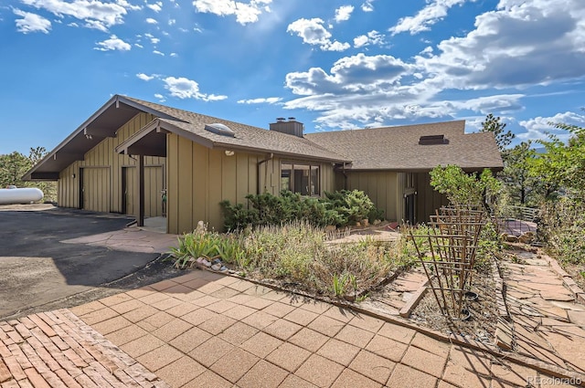 135 Poorman Rd, Boulder, CO 80302 - ranch-style house with board and batten siding, a chimney, and roof with shingles