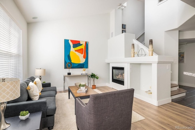 14000 Winding River Ct Unit T3, Broomfield, CO 80023 - living room featuring wood finished floors, a glass covered fireplace, and high vaulted ceiling