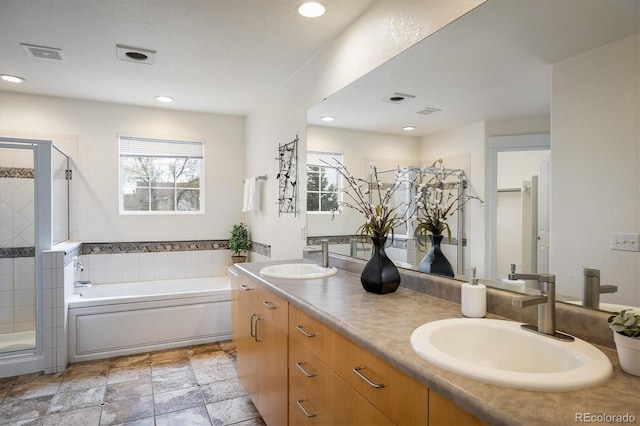 14000 Winding River Ct Unit T3, Broomfield, CO 80023 - bathroom featuring a garden tub, double vanity, a stall shower, and recessed lighting