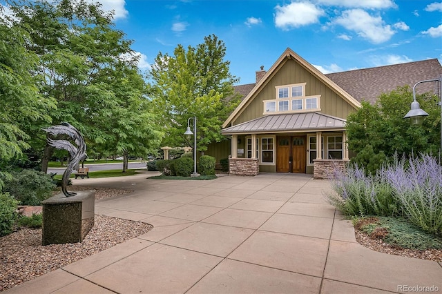 14000 Winding River Ct Unit T3, Broomfield, CO 80023 - view of front of home featuring board and batten siding, a standing seam roof, stone siding, a chimney, and french doors