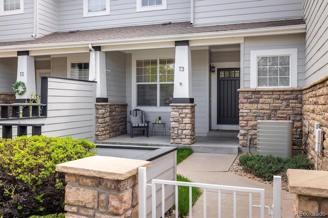 14000 Winding River Ct Unit T3, Broomfield, CO 80023 - doorway to property featuring a porch, stone siding, and roof with shingles