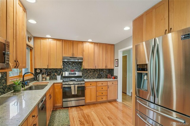40 S 34th St, Boulder, CO 80305 - kitchen with stainless steel appliances, under cabinet range hood, light wood finished floors, decorative backsplash, and light stone counters