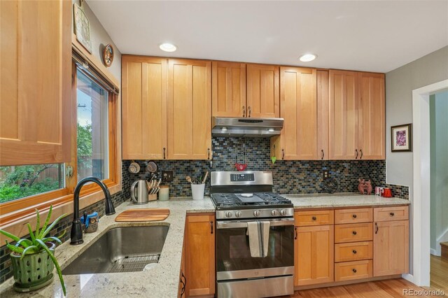 40 S 34th St, Boulder, CO 80305 - kitchen with stainless steel gas stove, under cabinet range hood, tasteful backsplash, light stone countertops, and recessed lighting