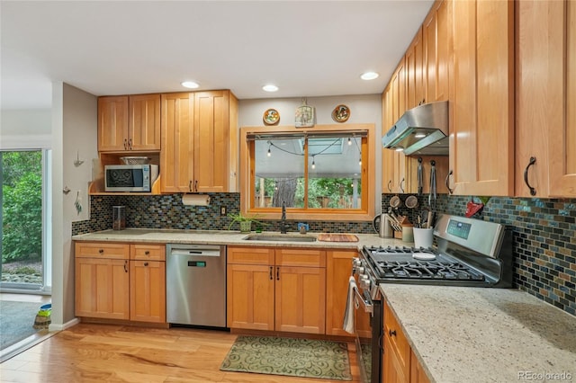 40 S 34th St, Boulder, CO 80305 - kitchen with appliances with stainless steel finishes, under cabinet range hood, light wood-style flooring, light stone counters, and backsplash