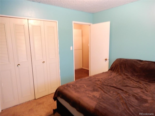 carpeted bedroom with a textured ceiling and a closet